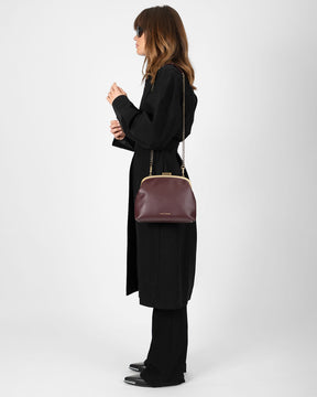 Sac EMMA Aubergine porté en bandoulière chaîne, vue de profil sur modèle