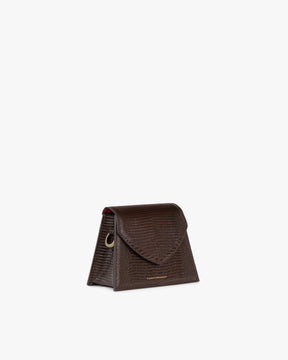 Sac GABRIELLE brun embossé lézard, vue de profil, posé, rabat pointu et anneau métallique visibles