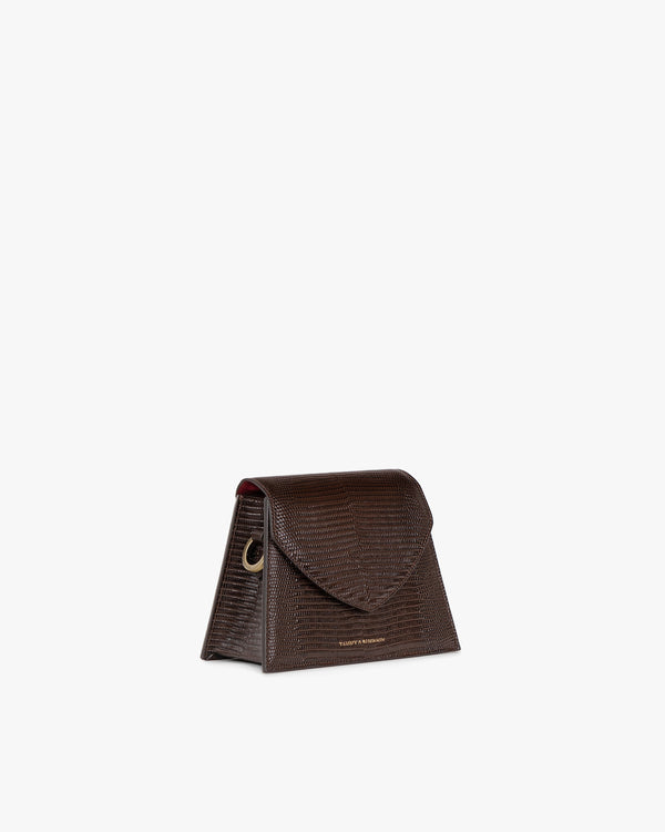 Sac GABRIELLE brun embossé lézard, vue de profil, posé, rabat pointu et anneau métallique visibles