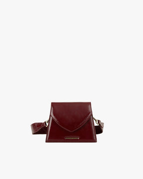 GABRIELLE bag in burgundy naplak, front view standing, pointed flap and shoulder strap visible