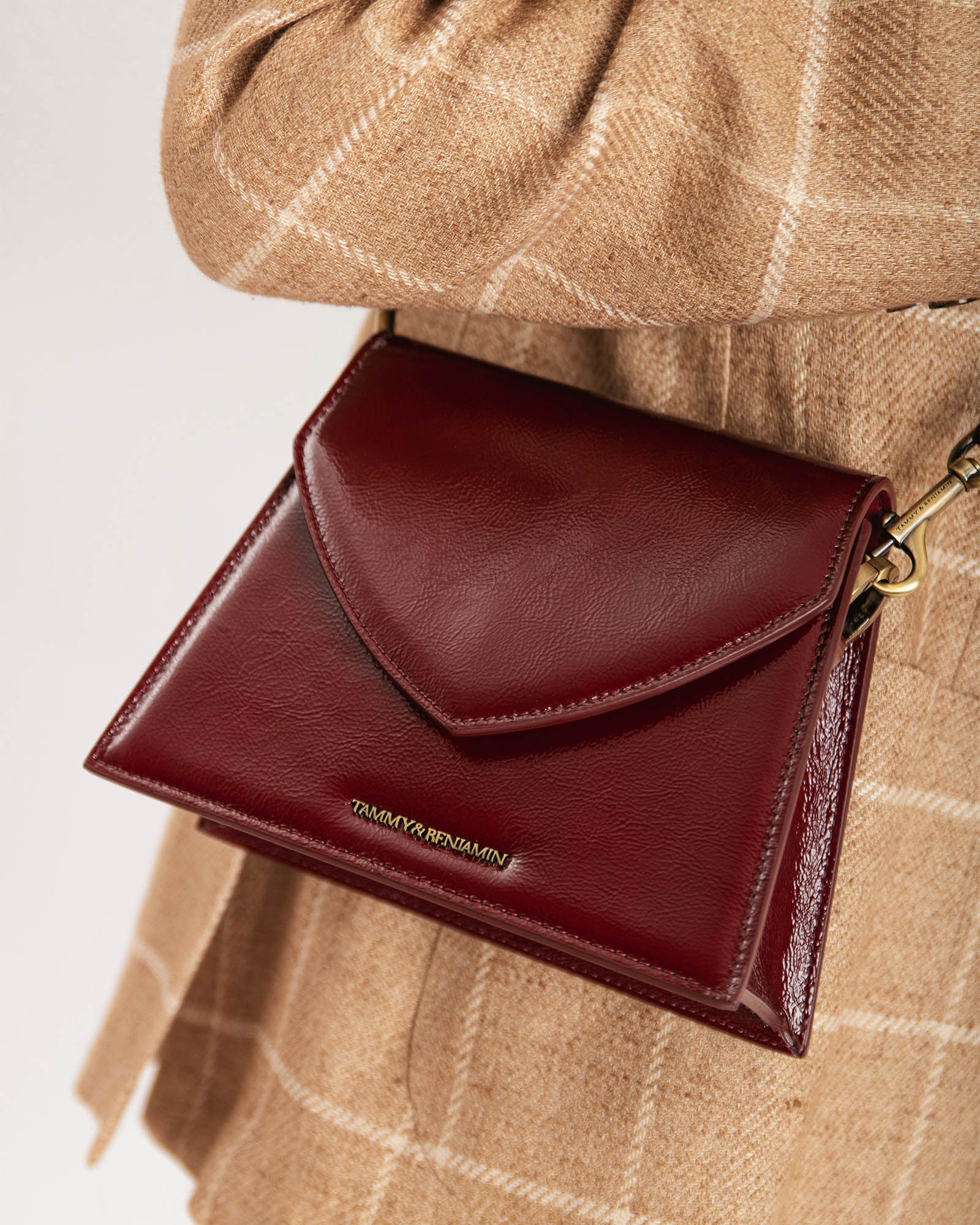 GABRIELLE bag in burgundy naplak, pointed flap, worn on the shoulder, close-up of gold-tone clasp