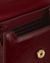 GABRIELLE bag in Bordeaux naplak, open view showing interior card slots and gold snap button