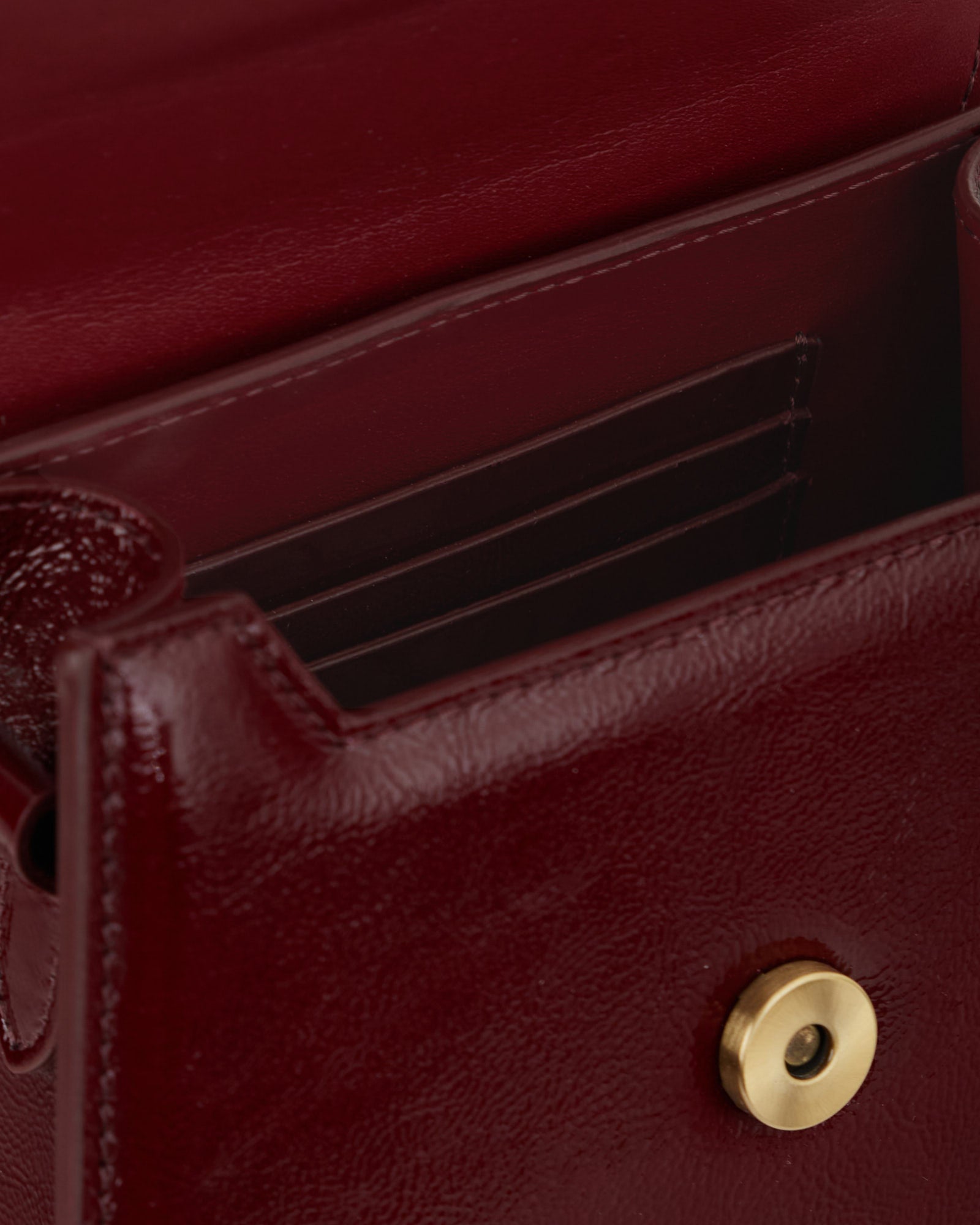 GABRIELLE bag in Bordeaux naplak, open view showing interior card slots and gold snap button
