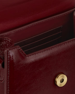 GABRIELLE bag in Bordeaux naplak, open view showing interior card slots and gold snap button