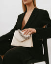 GABRIELLE bag in ivory, held in hand, close-up on the thick detachable chain