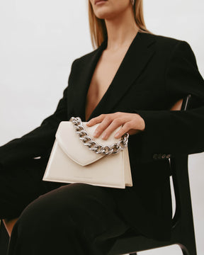 GABRIELLE bag in ivory, held in hand, close-up on the thick detachable chain