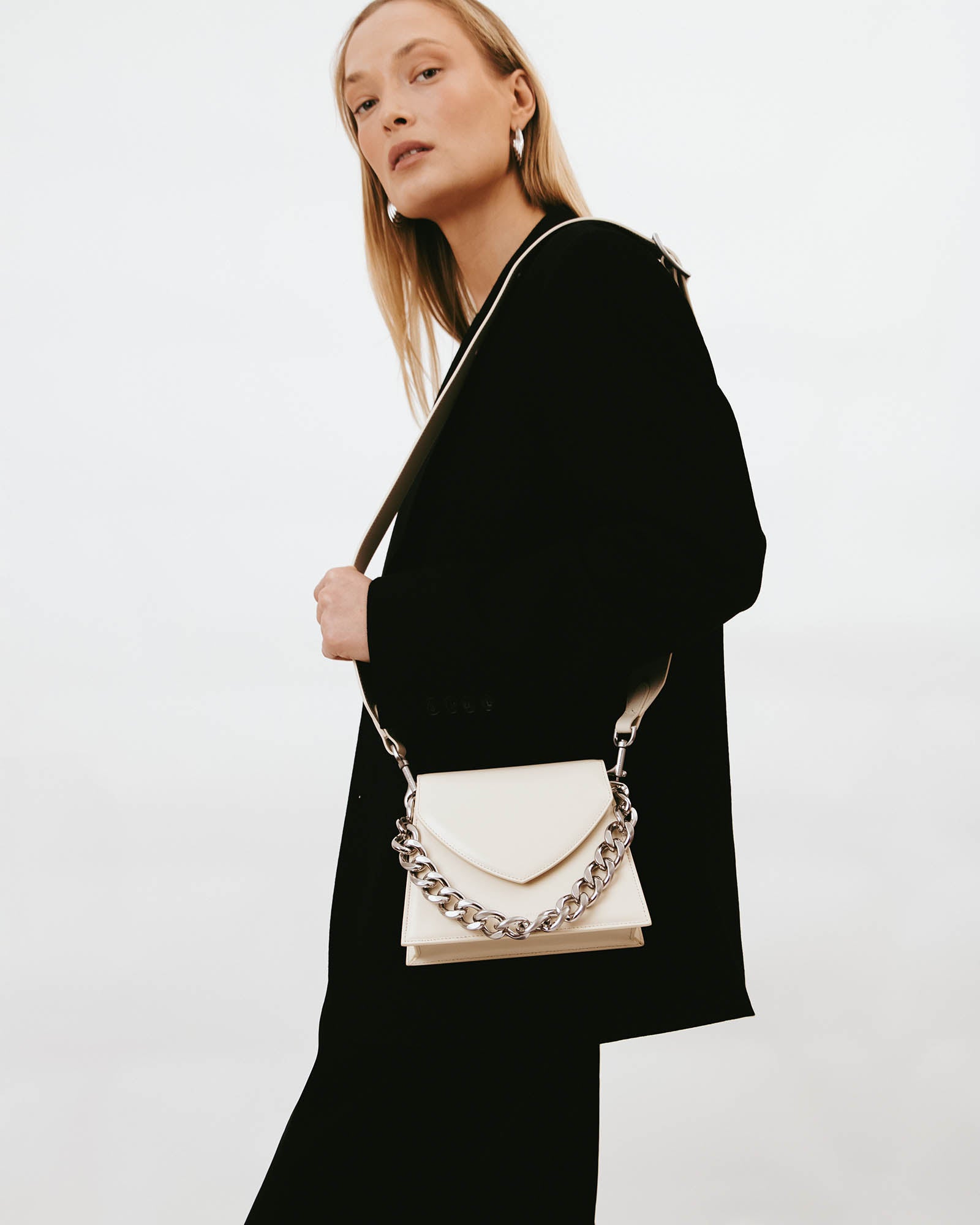 GABRIELLE bag in Ivory worn on the shoulder, side view, detachable chain on the leather strap