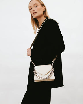 GABRIELLE bag in Ivory worn on the shoulder, side view, detachable chain on the leather strap