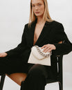 GABRIELLE bag in Ivory held in hand, pointed flap and detachable short chain, seated shot