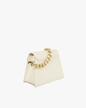 GABRIELLE bag in ivory, three-quarter view, trapeze silhouette with pointed flap and thick gold chain on top