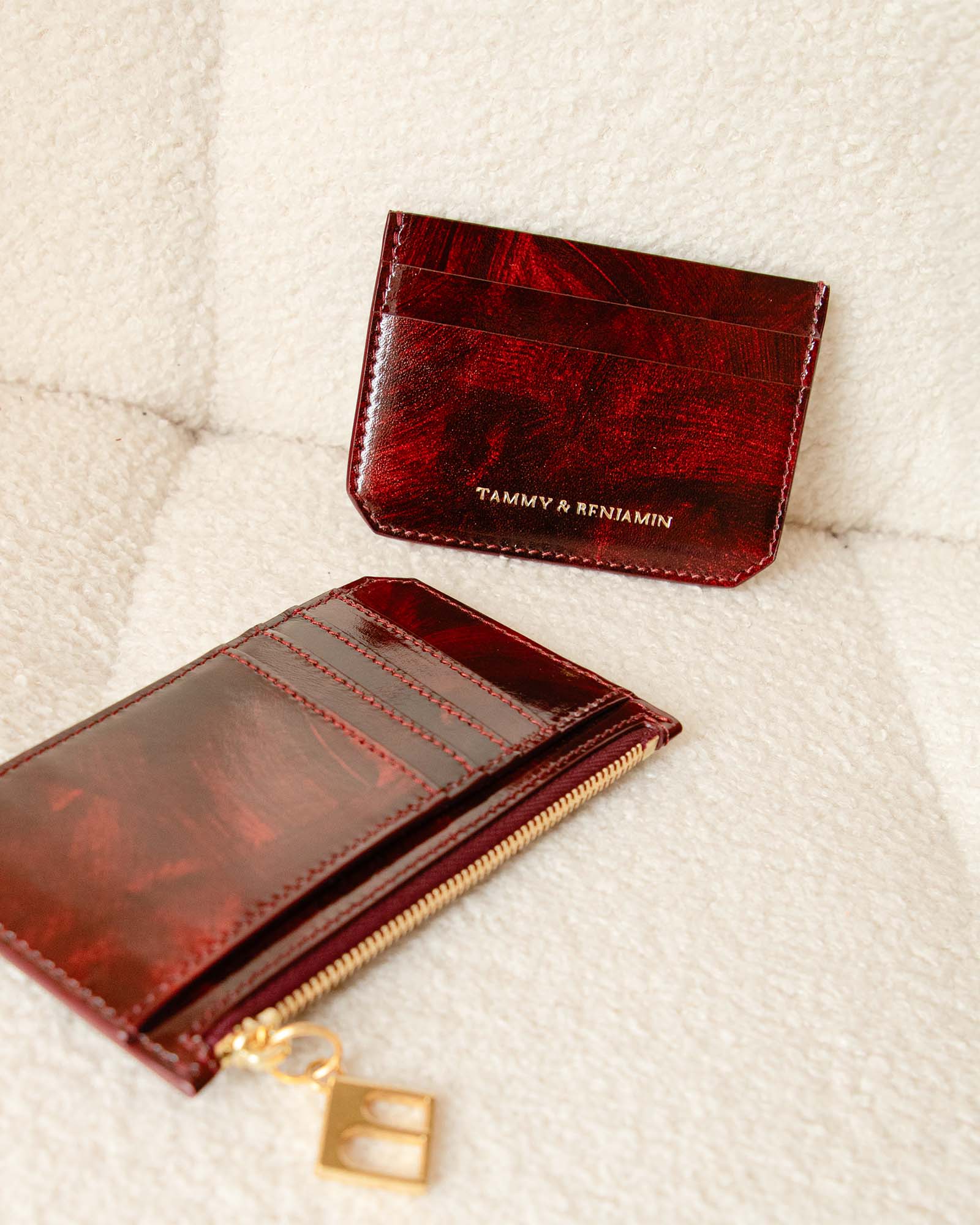 Porte-cartes CARDY Marbre en cuir, fermé et ouvert avec zip et breloque dorée, posés côte à côte
