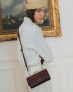 Sac JEANNE BAGUETTE Mahogany porté en bandoulière, vu de profil sur une tenue blanche