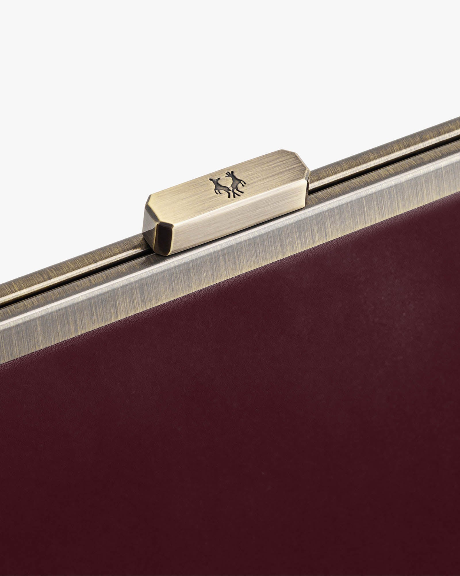 Sac JEANNE Mahogany, détail du fermoir métallique gravé et du cuir bordeaux