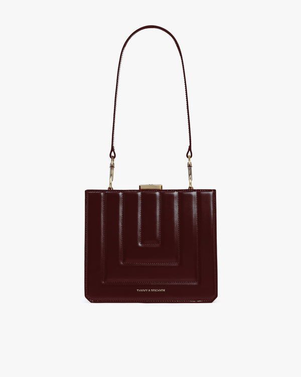 Sac JUDE mahogany matelassé de face, posé, avec anse bandoulière, fermoir doré et surpiqûres apparentes