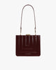 Sac JUDE mahogany matelassé de face, posé, avec anse bandoulière, fermoir doré et surpiqûres apparentes|upsale-option--bandouliere-courte-mahogany-1