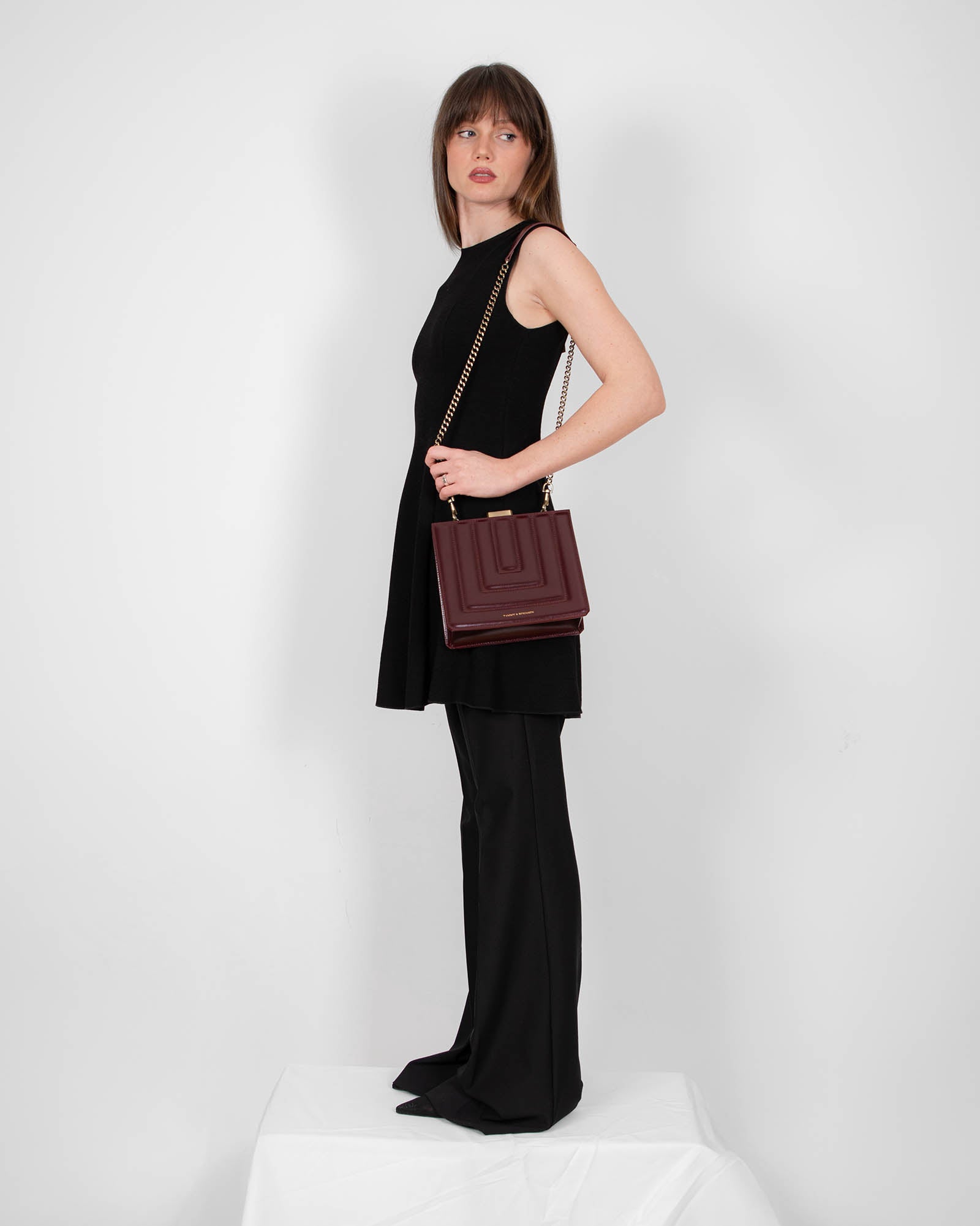 JUDE bag in quilted Mahogany, worn crossbody with gold chain, side view