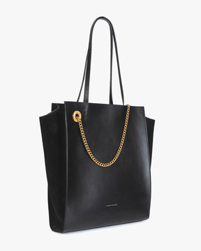 Sac LEXI GM noir, vue de trois quarts, posé, anses portées, chaîne amovible dorée visible