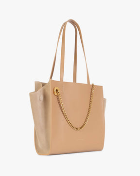 Cabas LEXI MM beige de trois quarts, anses en cuir et chaîne amovible dorée, panneau en suède sur le côté