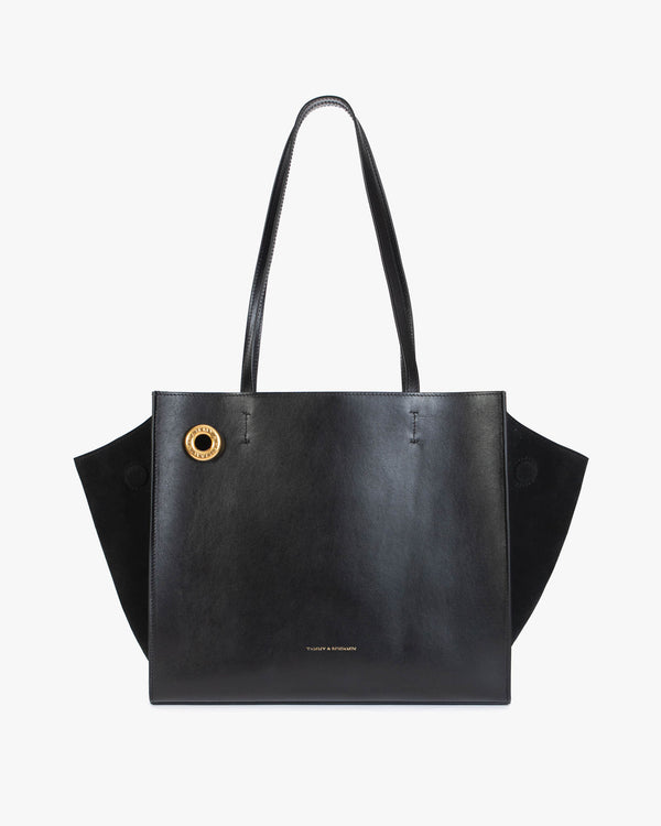 Sac LEXI MM en noir, vue de face, posé, avec anses longues en cuir et ailes en suède