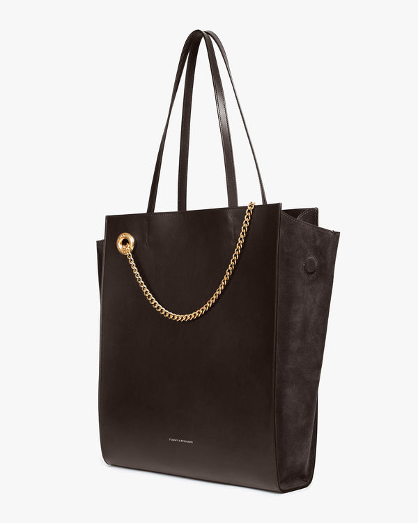 Cabas LEXI GM chocolat vu de trois quarts, anses portées, détail de la chaîne dorée amovible