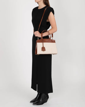 MADISON bag in brown and canvas worn crossbody, side view on model