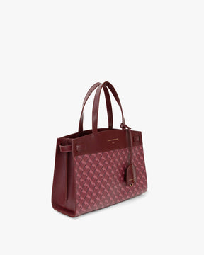Sac MADISON Bordeaux vu de trois quarts, posé, anses courtes, motif monogramme et cuir lisse