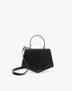 Sac PENTAGONE noir de trois-quarts, poignée structurée relevée et bandoulière détachée posée devant
