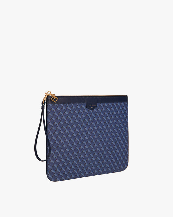 Pochette GM Monogram bleue, vue de trois quarts, dragonne en cuir détachée posée sur le côté