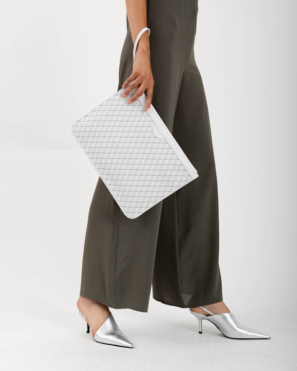 Pochette GM Monogram ivoire tenue à la main par la dragonne, motif tressé, porté détail