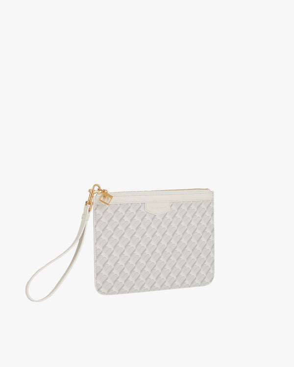 Pochette PM Monogram blanc ivoire de trois quarts, dragonne en cuir détachée posée sur le côté