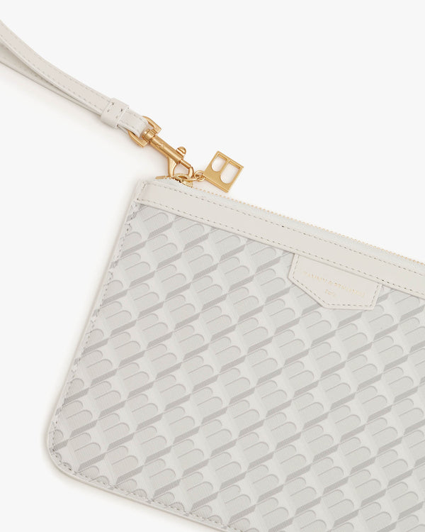 Pochette PM Monogram en ivoire, détail du zip et de la dragonne en cuir avec breloque dorée