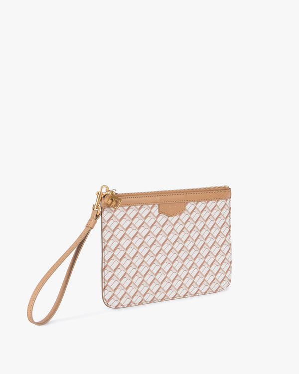 Pochette PM Monogram Tan vue de trois quarts, dragonne en cuir posée au sol