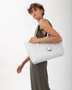 TOTE MONOGRAM blanc ivoire, porté épaule, vue de profil sur mannequin