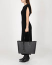 TOTE MONOGRAM noir, porté à la main, vue de côté sur mannequin