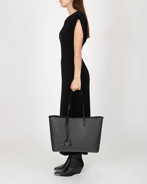TOTE MONOGRAM noir, porté à la main, vue de côté sur mannequin