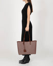 TOTE MONOGRAM brown carried on shoulder, side view on model, leather handles