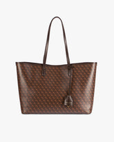 TOTE MONOGRAM Chocolat posé de face, anses plates en cuir, motif monogram sur toile enduite