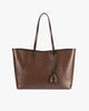 TOTE MONOGRAM Chocolat posé de face, anses plates en cuir, motif monogram sur toile enduite