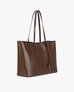 TOTE MONOGRAM Chocolat, vue de trois quarts, anses longues en cuir posées sur l'épaule