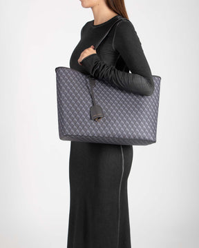 TOTE MONOGRAM gris porté à l'épaule, vue de profil sur mannequin, anse plate en cuir