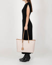 TOTE MONOGRAM Tan porté à la main, vue de profil, motif monogramme et anses en cuir