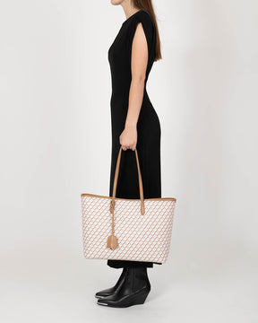 TOTE MONOGRAM Tan porté à la main, vue de profil, motif monogramme et anses en cuir