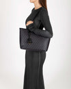 TOTE MONOGRAM PM noir, porté à l'épaule, vue de profil, en toile enduite Marble Arch