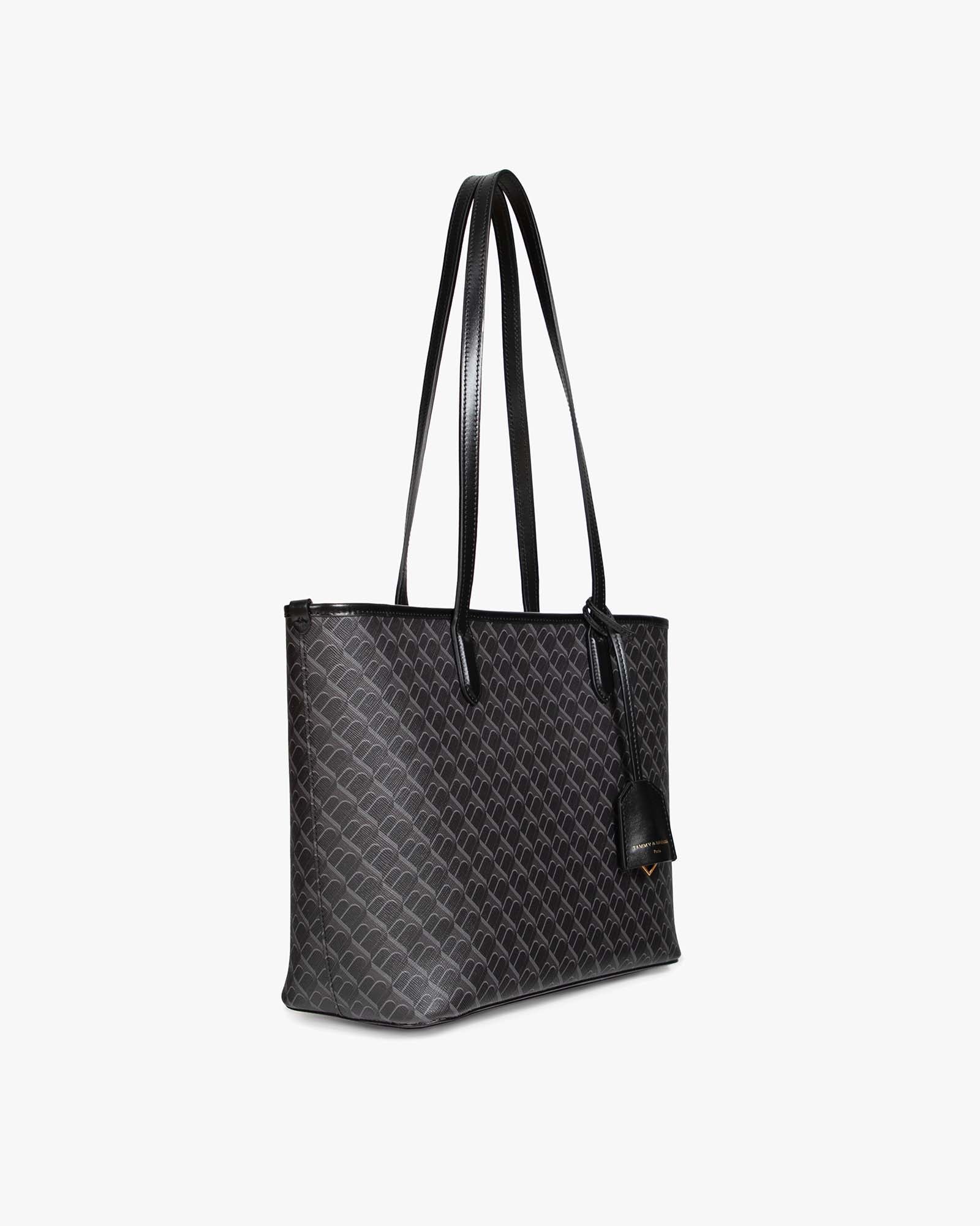 Sac TOTE MONOGRAM PM noir monogram, vue de profil, porté à l'épaule par ses anses plates en cuir