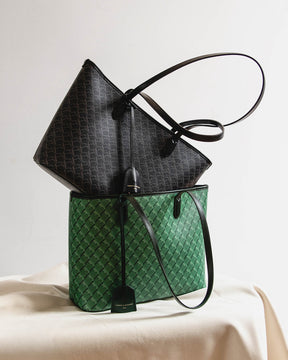 TOTE MONOGRAM PM vert, posé sur un tissu, anses noires, sac monogram noir glissé à l'intérieur