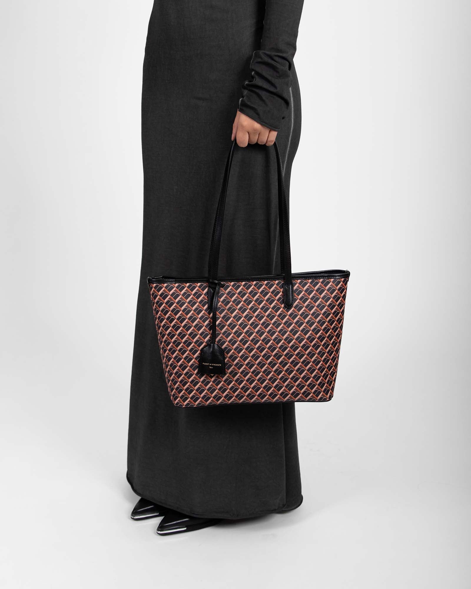TOTE MONOGRAM PM brown and black, carried by hand, side view on model