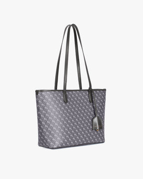TOTE MONOGRAM PM gris, vue de côté posé, anses jointes, porte-étiquette en cuir en évidence