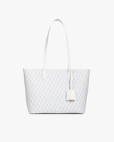 TOTE MONOGRAM PM blanc ivoire, vue de face posé, anses plates et porte-adresse en cuir