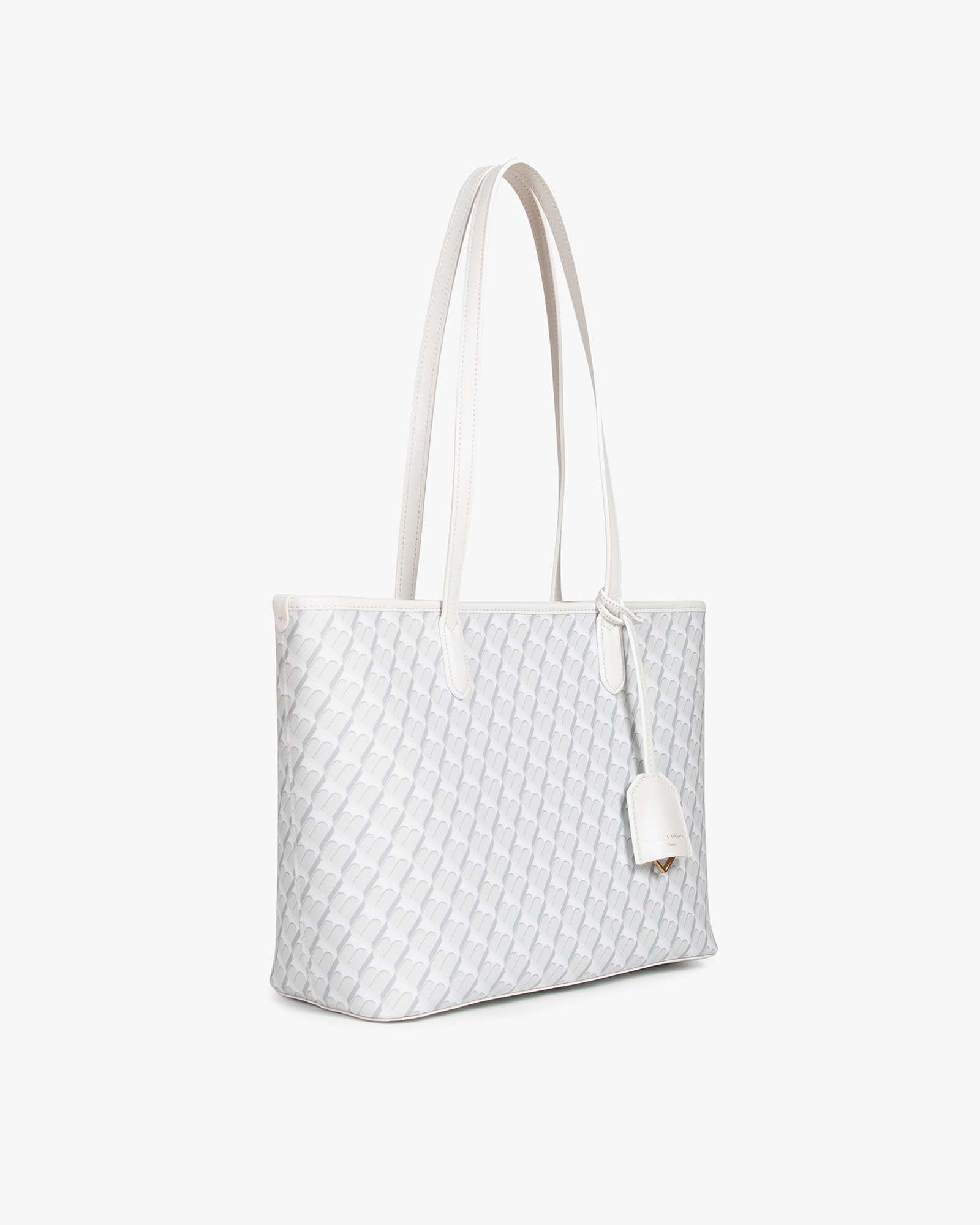 TOTE MONOGRAM PM ivoire, vue de trois quarts, anses plates, étiquette pendante logo doré