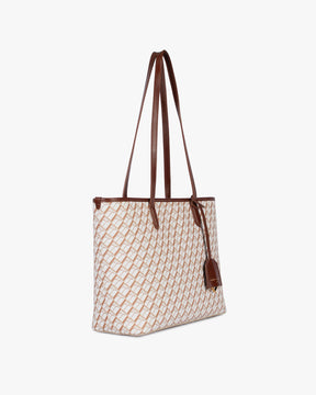 TOTE MONOGRAM PM Tan, vue de profil, porté à l'épaule par les deux anses en cuir, toile enduite à motif